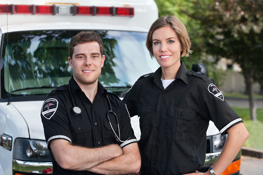 Contact - Two Paramedics Standing in Front of Ambulance